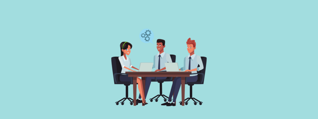 Three animated business professionals sit around a table with laptops, collaborating and discussing work, with a light blue background and a gear icon above them symbolizing teamwork.
