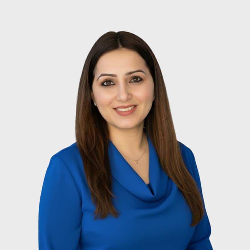 A woman with long brown hair and a blue blouse smiles at the camera against a plain light gray background, representing an IT staffing agency in Toronto.